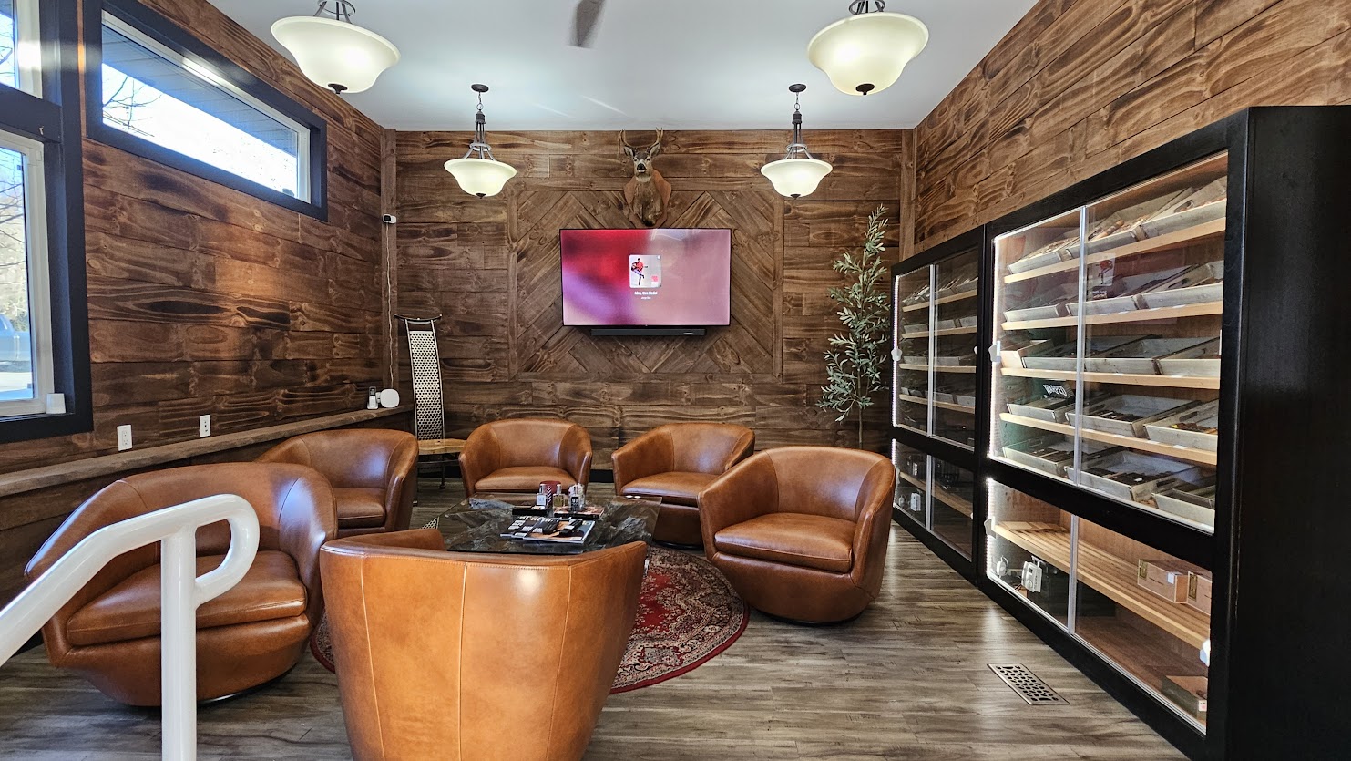 Completed lounge with wood wall finishes, leather seating, and glass display cabinets