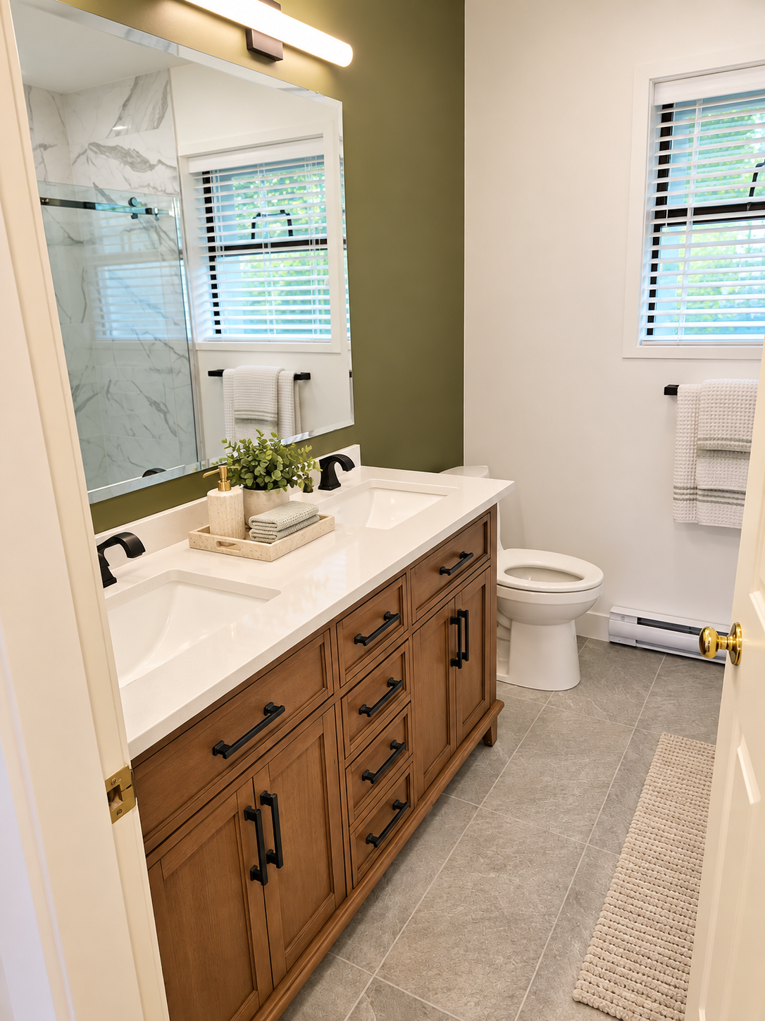 Bathroom with wood double vanity, olive accent wall, and black fixtures